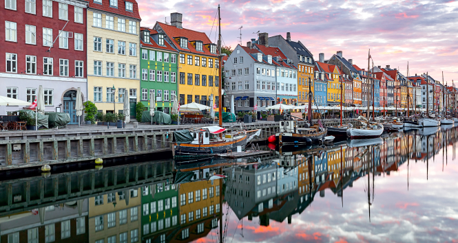 Copenhagen. Nyhavn Canal, colorful houses and city embankment at sunrise.